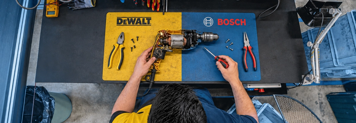 Técnico reparando herramientas BOSCH y DEWALT en el taller